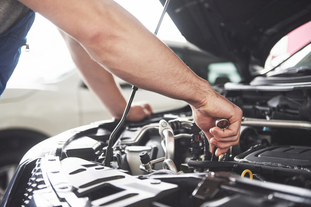 Car Modification Cardiff. Close up hands of unrecognizable mechanic doing car service and maintenance.